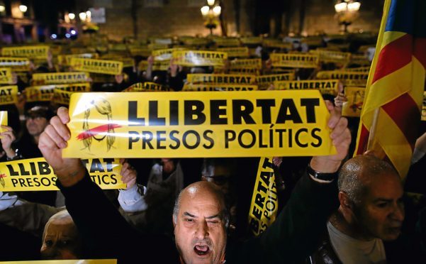 Demonstrators holding banners reading in Catalan "freedom for the political prisoners" gather outside the Palau Generalitat, during a protest against the decision of a judge to jail ex-members of the Catalan government.