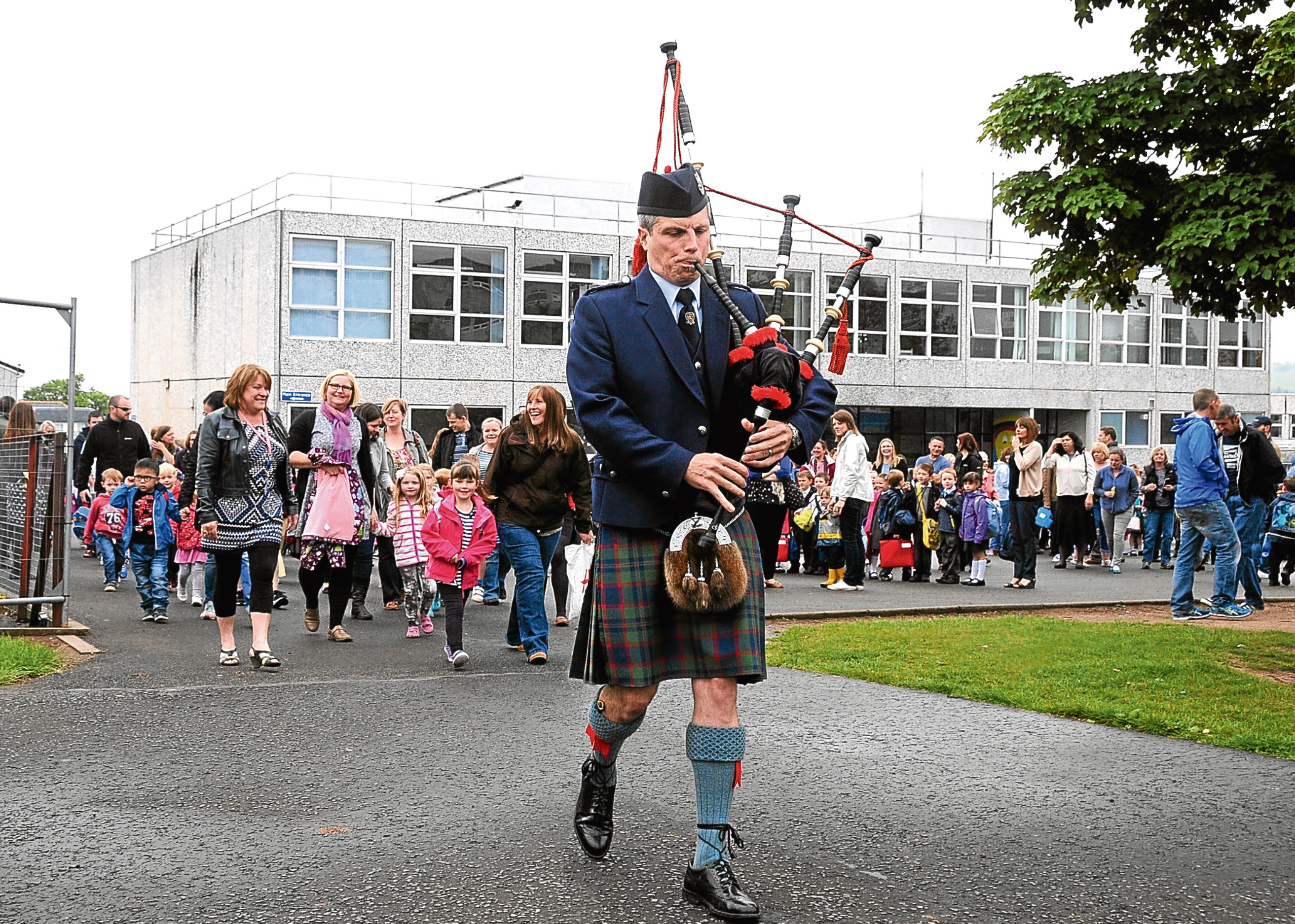 Pupils from Perth’s Oakbank Primary School march into their new school building in 2015, led by piper Adam Scrimgeour.
