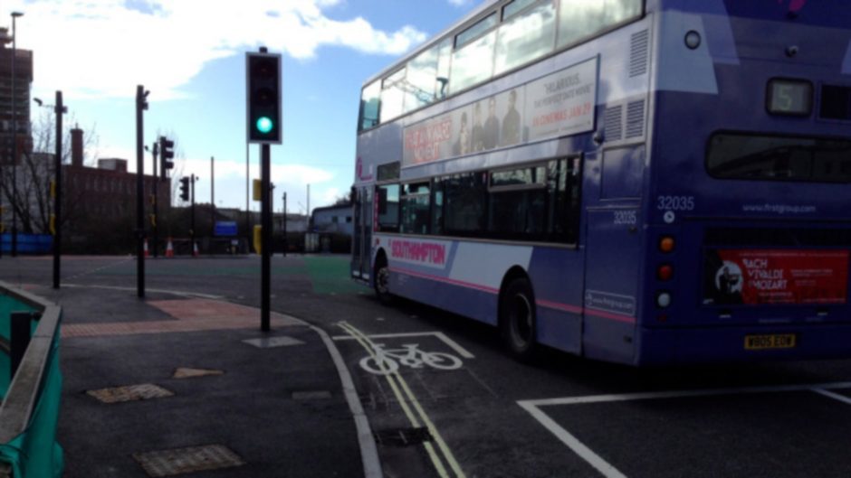 a bus drives by alongside a cycle lane