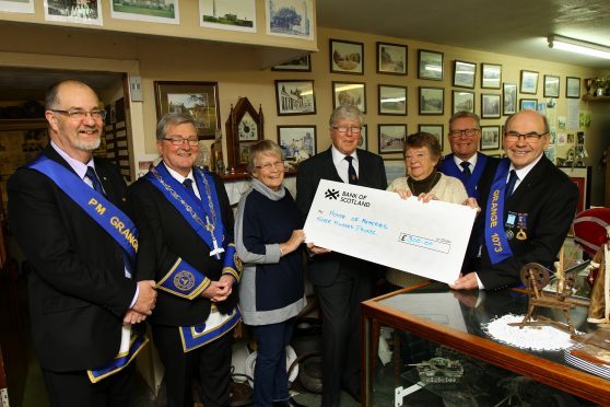 Margaret Copland, 3rd from right, President of the Monifieth Local History Society, and Linda Spalding, 3rd left, Administrator, receiving the cheque for £300 from members of Lodge Grange 1073, L/R, Harry Conway - Past Master, Sam McFadzean - Senior Warden, Bruce Duguid - Past Master, Jim Laing - Immediate Past Master and James Keir - Past Master, at the Monifieth House Of Memories