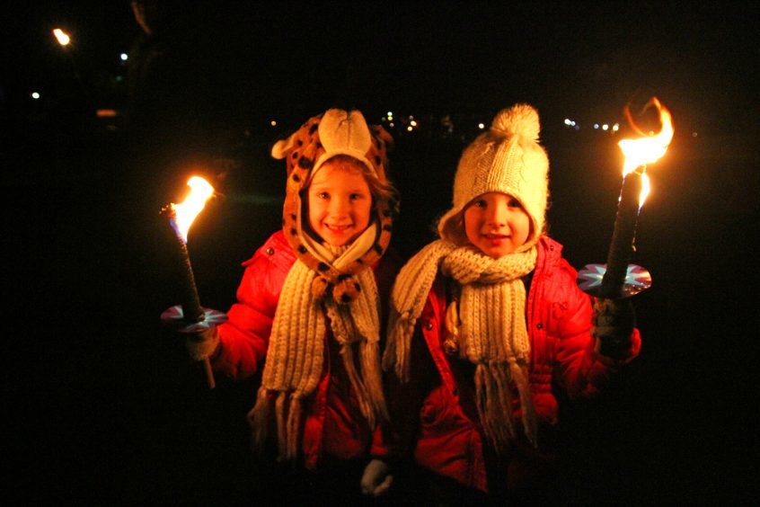 Twins Brooke & Bonnie Sturrock take part in the torch light parade.