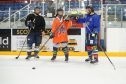 Dundee Stars coach Omar Pacha and player Gabriel Levesque show Gayle some basic ice hockey skills.