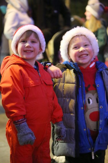 Ryan Dick and Lewis Atkinson in Santa hats in the square in Kirriemuir as the Christmas lights are switched on.