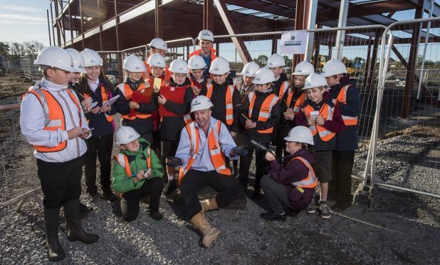 Site manager Stuart Giles with the young reporters.
Sixteen pupils from eight local primary schools (two from each) visited the site of the new Bertha Park High School – part of the new Bertha Park Village on the outskirts of Perth.