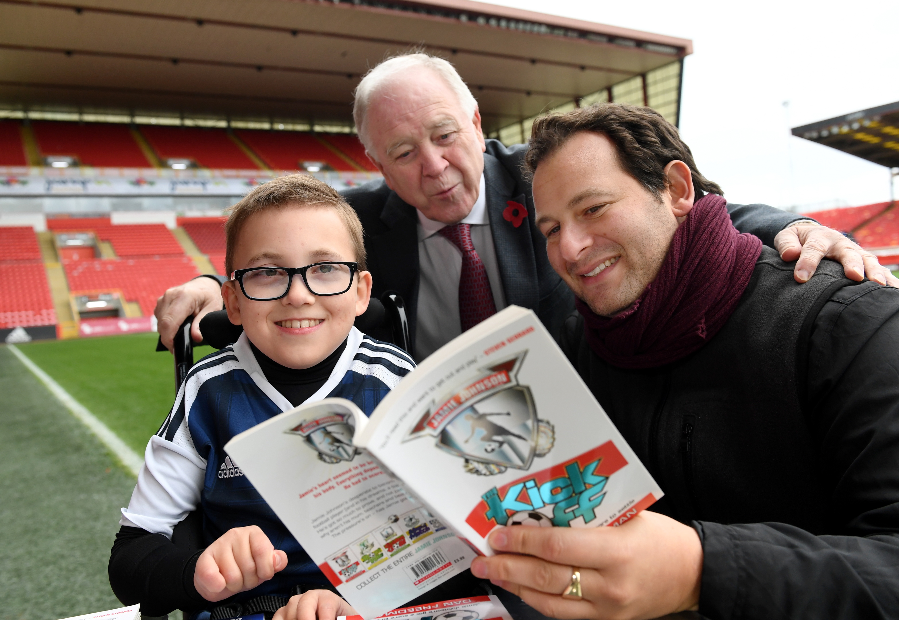 Finlay Sangster meets children's author Dan Freedman (right) and former Scotland and Aberdeen manager Craig Brown, at Pittodrie Stadium.