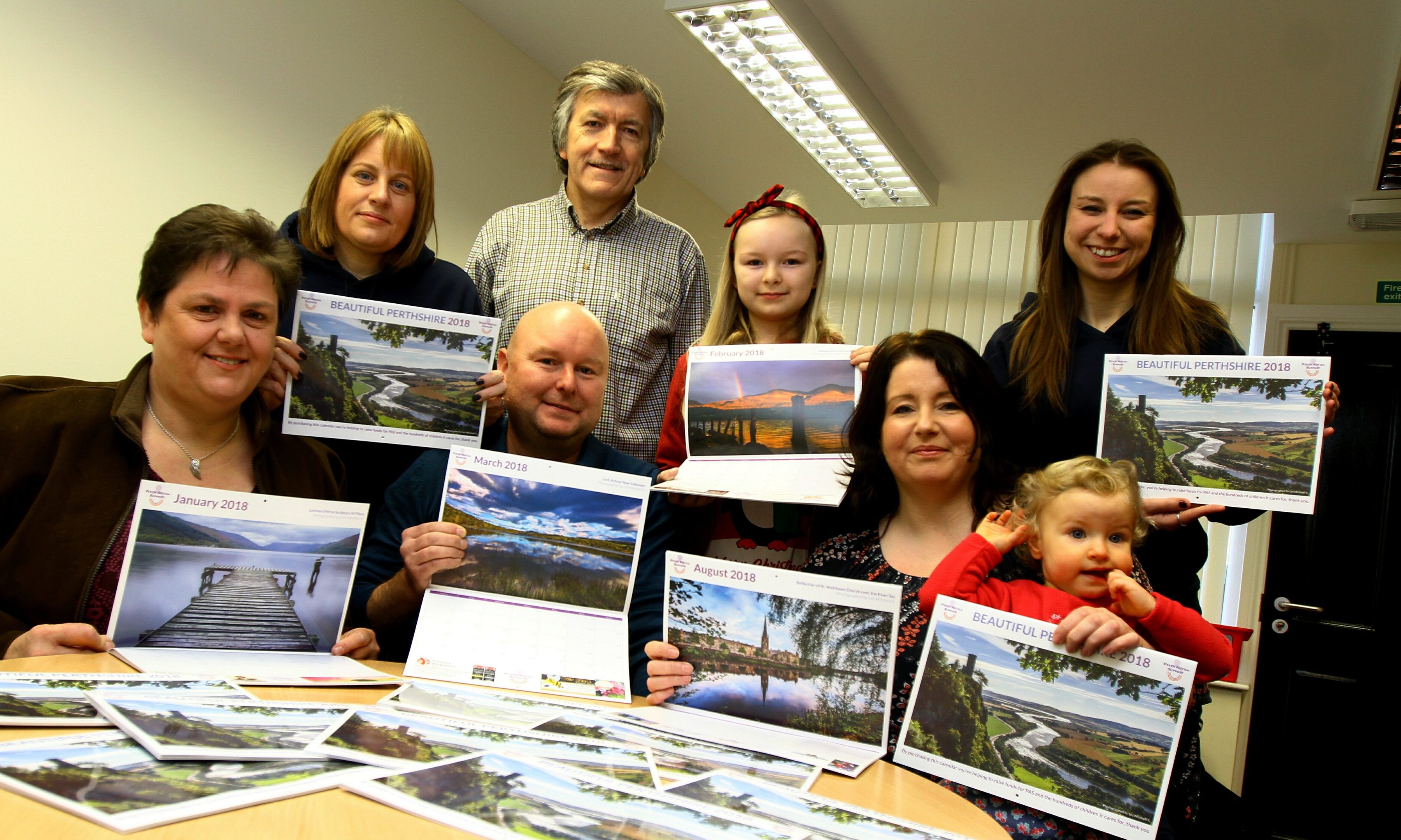 Parents Kath Booth, Craig Burnett, Gillian Anderson with daughter Ellis, and (back L/R) Angie Ferguson - Chief Executive Perth Autism Support, Les Mitchell - one of the photographers for the calendar, Katie Burnett (Craig's daughter and Teri Slorach - Childrens Services Manager, at the launch of the calendar in the offices of Perth Autism Support.