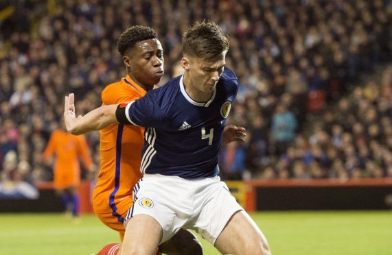 Kieran Tierney holds off Holland player Quincy Promes.