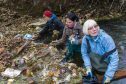 Dighty Connect's Jayne Wilkinson and Catherine Rice pull rubbish from the burn, with help from Gayle Ritchie (in middle).