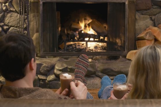 Couple relaxing by a fire