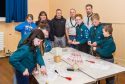 Councillor Angus Forbes with Scout Leaders Richard Prince and Cameron Peach and young Scouts in the community hall.
