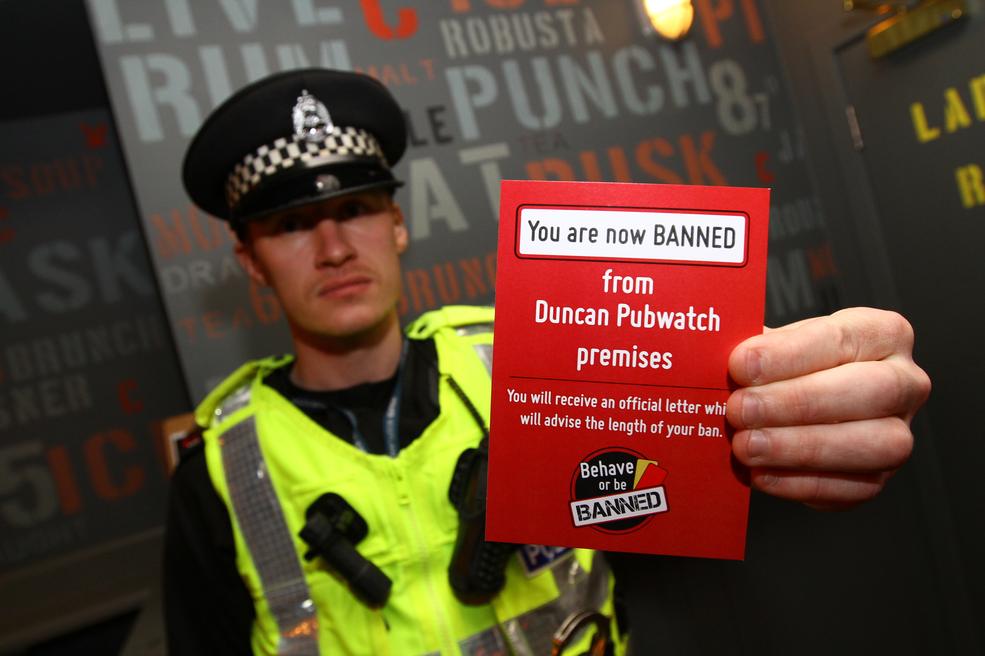 PC Mark Reid with the red card from the Behave Or Be Banned campaign.