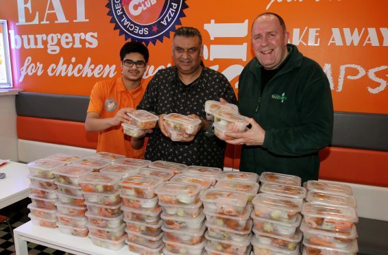 Ken Linton (right) of the Dundee Foodbank accepts meals from Daud Sheikh and Ibrar Ibrahim of the Chicken Club.