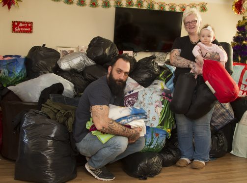 Christian with his daughter Elizabeth and his mum Lesley Whittet with mountains of donated gifts that he plans to distribute on Saturday.