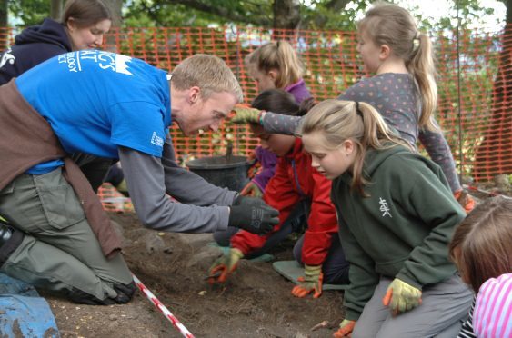 PKHT outreach officer Gavin Lindsay and AOC Archaeologist Katie Roper teaching P6 pupils from Royal School of Dunkeld how to dig and identify artefacts at the fort.