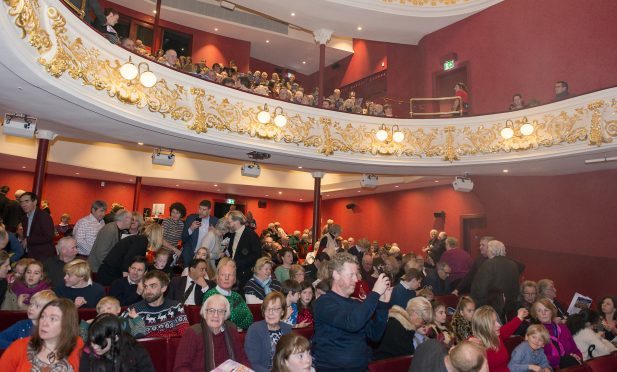 Members of the audience gather for the first performance inside the renovated theatre.