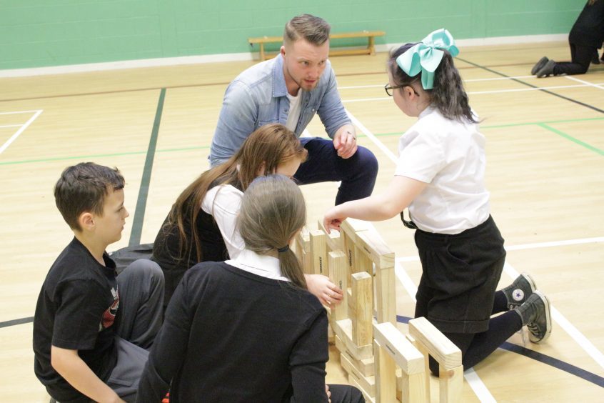 RAE4: Abertay 4th Year Civil Engineering student Stephen Brindle helps St Peter and Paul's Primary School children construct an archway using giant jenga blocks during Fife Science Festival at Craigowl PS.