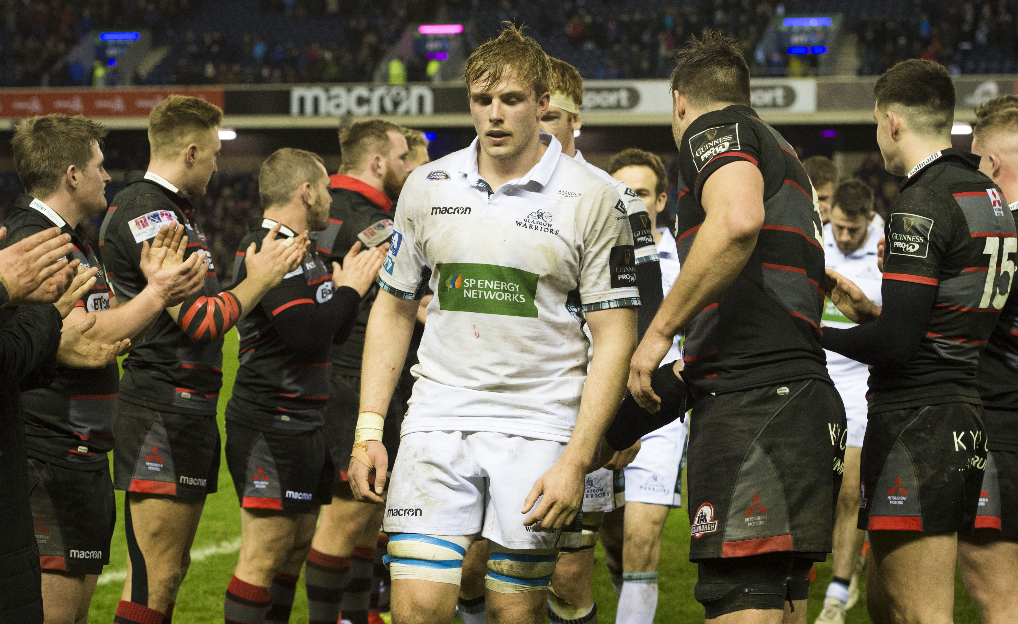 A dejected Jonny Gray walks through the ecstatic Edinburgh line-up after the first leg of the 1872 Cup.