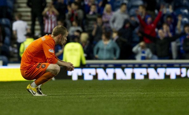 Scott Robertson's dejection tells the story of a 5-0 defeat at Ibrox in 2012.