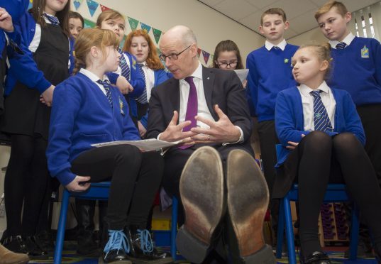 Maisondieu Primary School pupil Lexi Short (left) questions Deputy First Minister John Swinney.