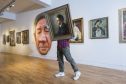 A worker carries an image for installation ahead of the opening of the double portraits exhibitions, Revealing Character and Face to Face, at the McManus in Dundee. Picture: Alan Richardson