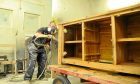 A worker puts the finishing touches to a sideboard unit at Dovetails base at Dunsinane industrial Estate.