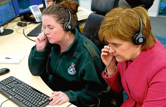 First Minister Nicola Sturgeon listens into a 999 call with Avril as she tours call centre and meets Scottish Ambulance Service call handlers, and NHS 24 staff in Cardonald Glasgow.