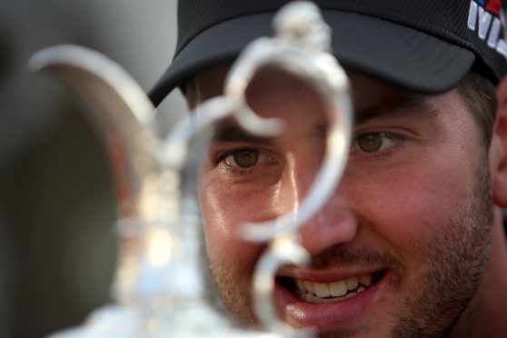 Bradley Neil checks some of the legendary names on the Claret Jug while promoting this July's Open at Carnoustie in Dundee .