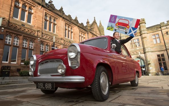 Emilia Kozlowska, 10, who won a competition to design the event start flag, pictured in the Ford Prefect of  Angus crew David Tindal, Alan Falconer and Stephen Woods