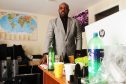 Oluwafani Oki in his Hilltown office with one of the drink bottles left behind by thieves visible on the desk.
