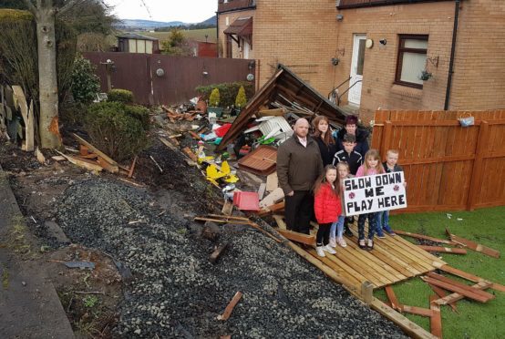 Councillor Darren Watt along with some of the families and local children living in fear, right beside the damage.