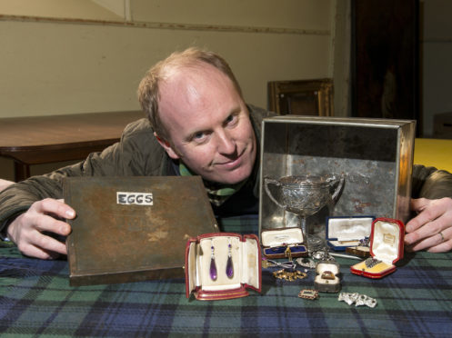 Auctioneer Nick Burns with the old tin box and Cartier items.