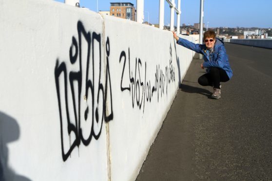 Christine May beside the vandalism on the promenade at Kirkcaldy.