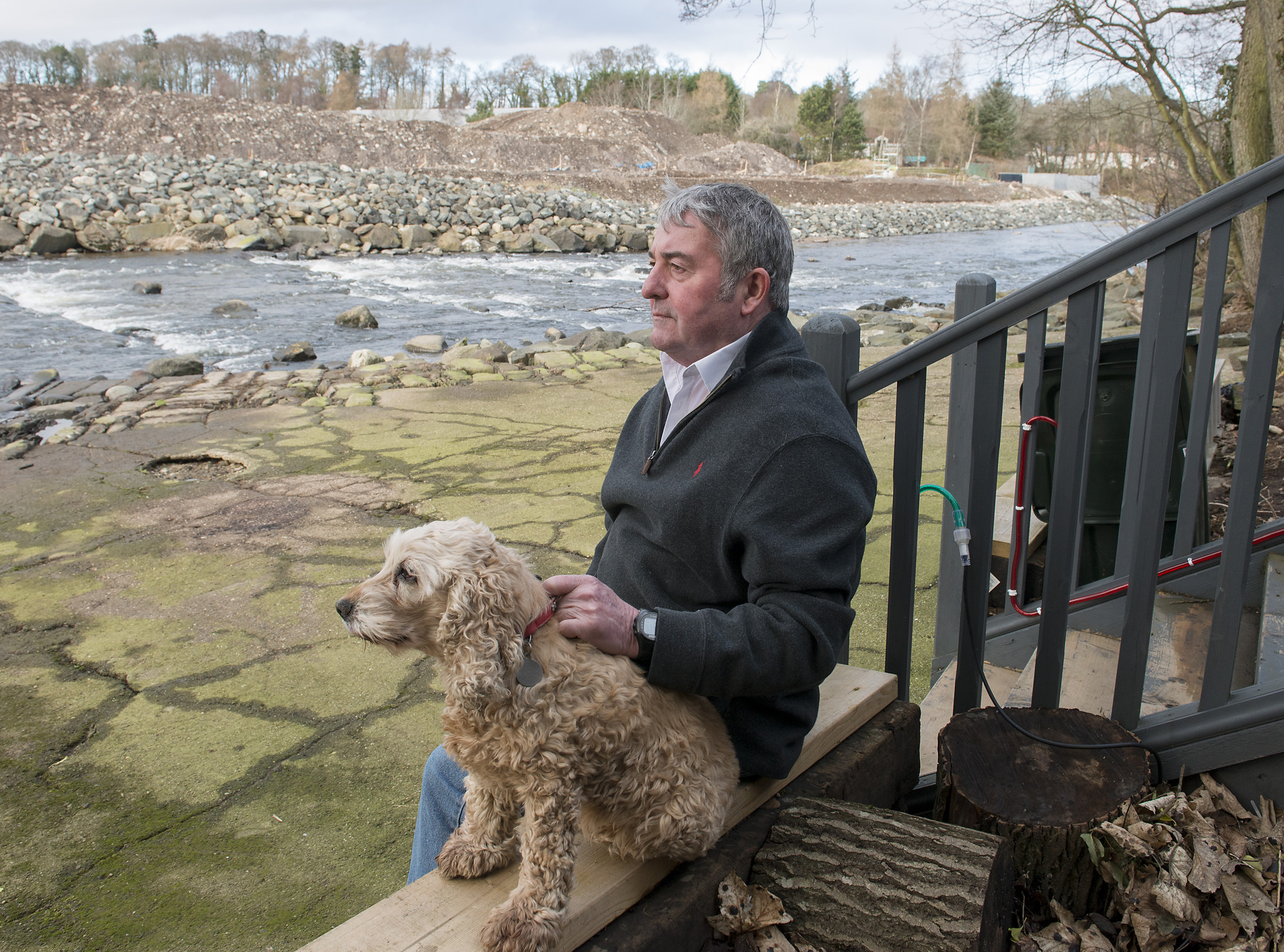 Mike Paton and his dog at his the riverside area, which he has been ordered to rip up.