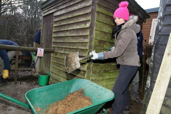 Gayle volunteers at Loch of the Lowes by helping to dig a trench for the new office.