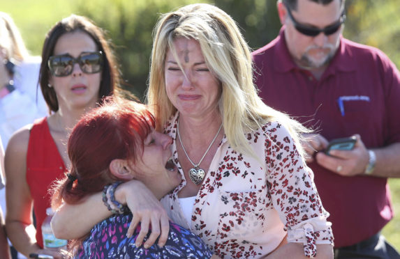 Parents wait for news after a reports of a shooting at Marjory Stoneman Douglas High School in Parkland, Fla., on Wednesday, February 14