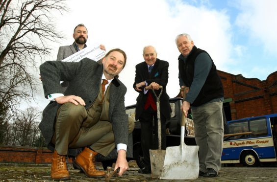 Chris Law MP lending a hand at the launch of the first phase of works on the former Maryfield Tram Depot, with L/R, Adam Swan - Director Dundee Historic Environment Trust, Norman Robertson - Trustee of the Dundee Museum of Transport and Jim McDonnell - Chairman.