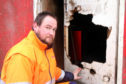 James Ross of Ramsay Skip hire beside some of the damaged property.