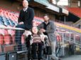 Richard Meiklejohn and Michael Leeland, of OOVIRT and wheelchair user Clair D'All at Tannadice park.