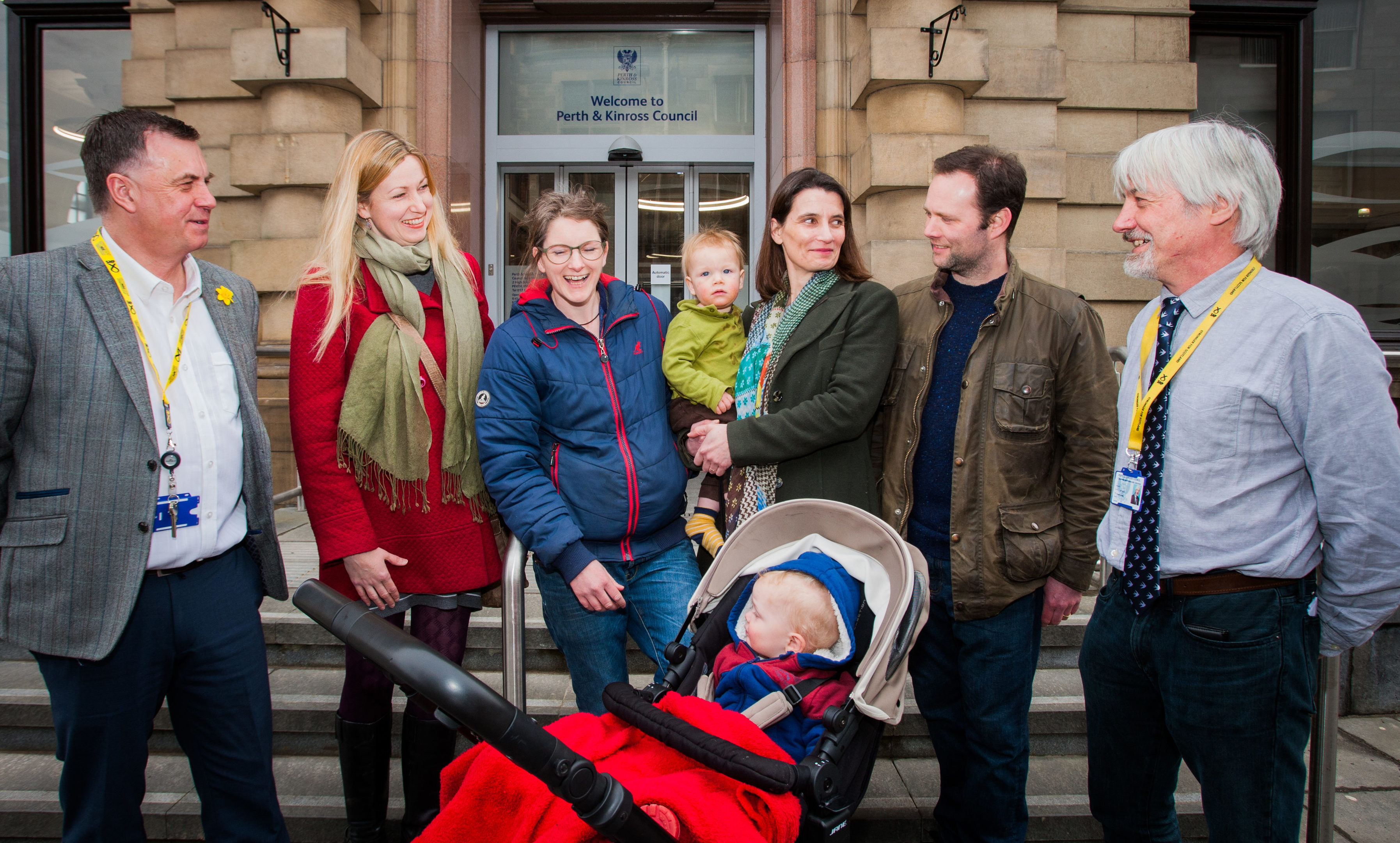 Left to right is Councillor John Rebbeck, alongside concerned parents Sarah Draper, Claudia Massie, her son Magnus Gibson (aged 18 months, in pram), Keesje Crawford-Avis (Chair of Logiealmond Parent Council), her son Ethan Crawford-Avis (aged 1) and husband Oliver Crawford-Avis, with Councillor Grant Laing.