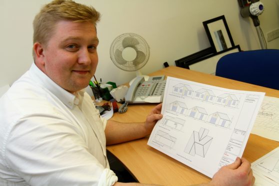 Owen Dyer with drawings of the proposed houses.