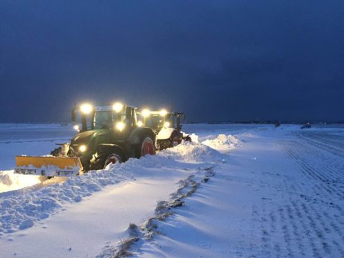Mike Young's tractor at work north of Anstruther on Thursday night with the stuck council gritter visible in the background