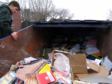 A volunteer sifts through the skip at the old school, with text books clearly visible.