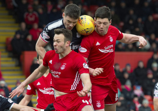 Darren O'Dea battles in the air with two Aberdeen men.