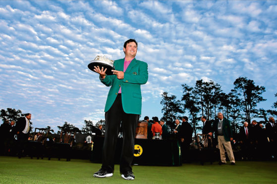 Patrick Reed holds the championship trophy after winning the Masters golf tournament Sunday, April 8, 2018, in Augusta, Ga. (AP Photo/David J. Phillip)