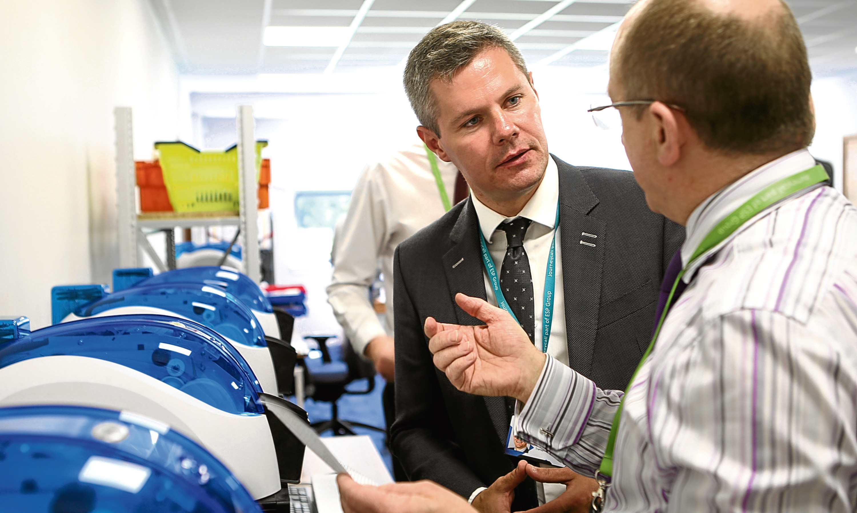 Cabinet Secretary for Finance Derek Mackay talks to a staff member during a ministerial visit to Journeycall in Arbroath.