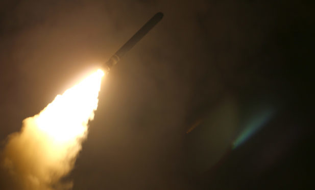 The guided-missile cruiser USS Monterey (CG 61) fires a Tomahawk land attack missile at Syria on April 13.