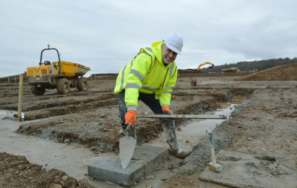 Bricklayer Peter McAninch lays the first bricks at the Bertha Park site.