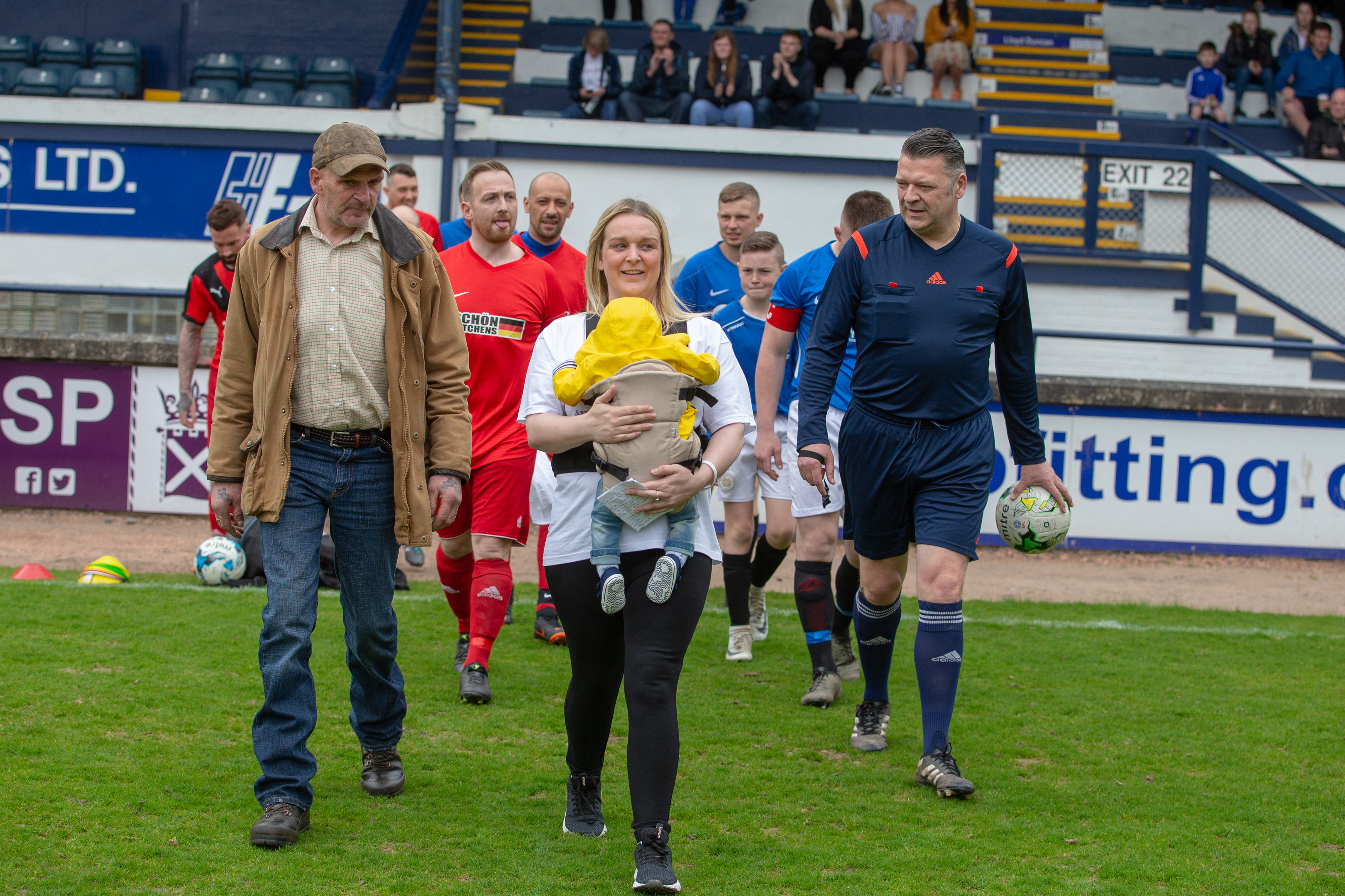 Ryan's partner Clare carrying son Hadden onto the pitch.