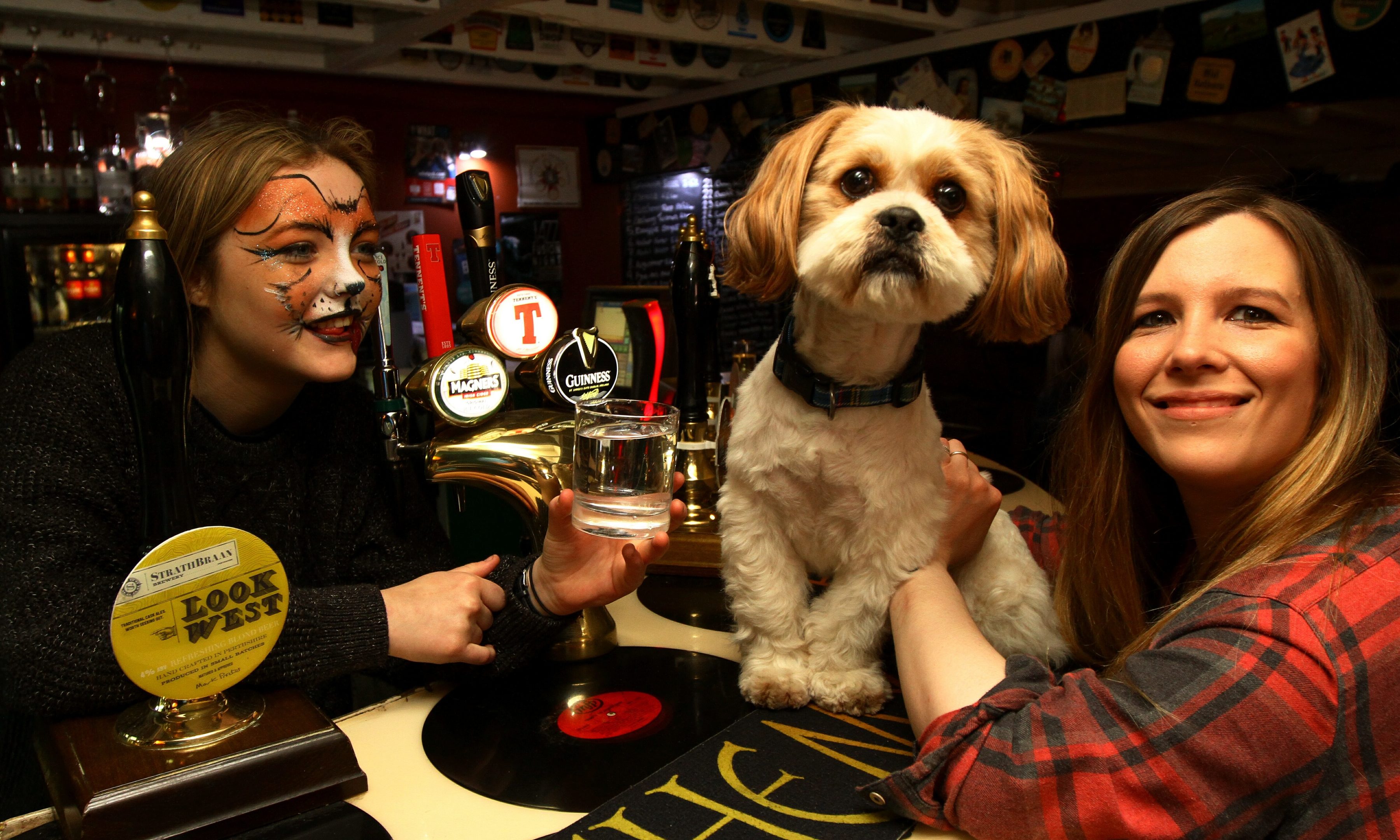 Katie McCandless Thomas, right, with her Lhasa Apso, Baxter being served a drink (of water!) by barmaid Olivia Watson.