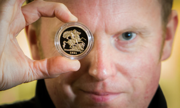 A collection of gold sovereign coins are expected to fetch large sums of money from upcoming auction. Picture shows 'Goldeneye' Nick Burns (auctioneer) with one of the coins.